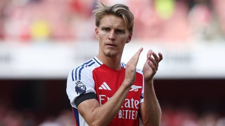 Martin Odegaard wearing the Arsenal captain armband and red home kit, orchestrating play in midfield — Norway captain and FPL creative midfielder rated high fatigue risk for GW1 2026/27