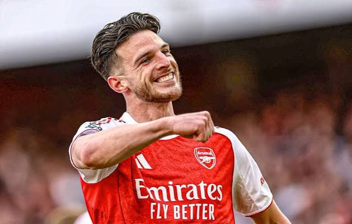 Declan Rice in an Arsenal home shirt driving forward with the ball — England midfielder and FPL set-piece threat rated medium fatigue risk for GW1 2026/27